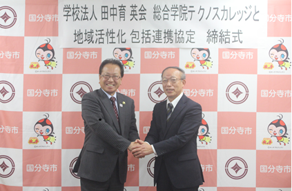 市長と学院長との固い握手の写真