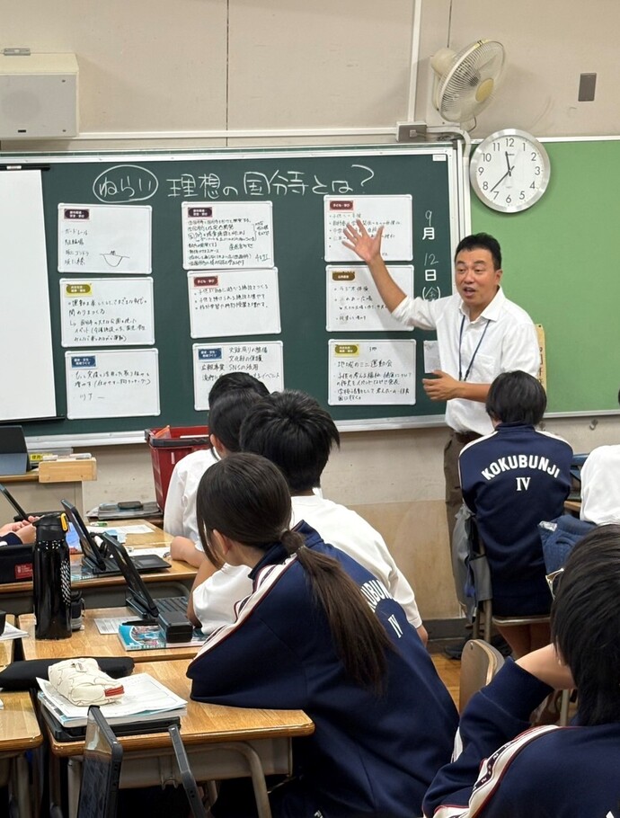 第四中学校の実践授業の様子（先生が生徒のグループワーク成果物を講評しているところ）