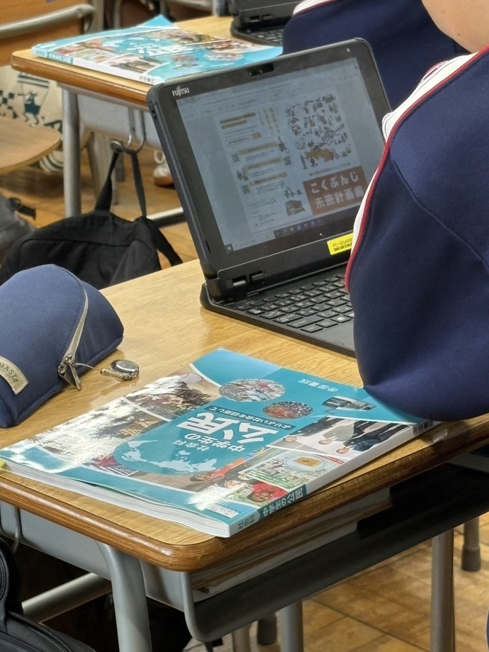 第四中学校の実践授業の様子（生徒のGIGA端末と公民の教科書）
