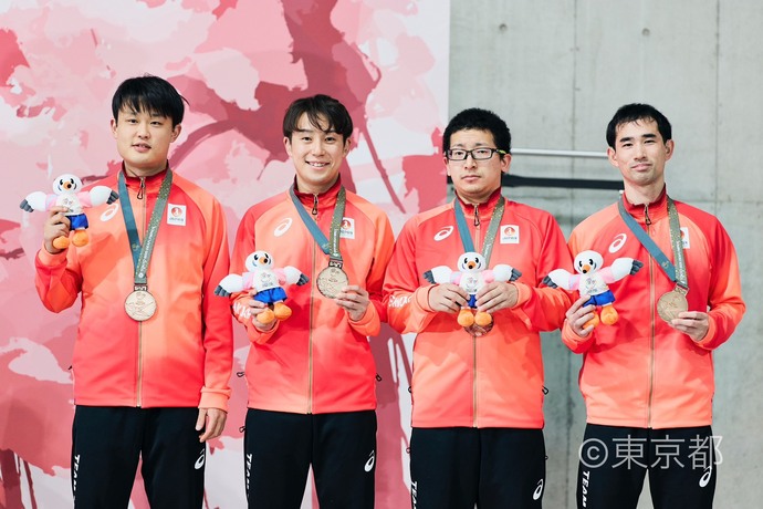 卓球競技男子団体戦の銅メダルを掲げる亀澤さん